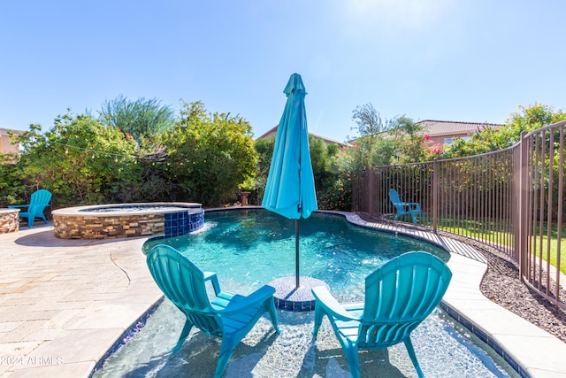 view of swimming pool featuring a patio, pool water feature, and an in ground hot tub