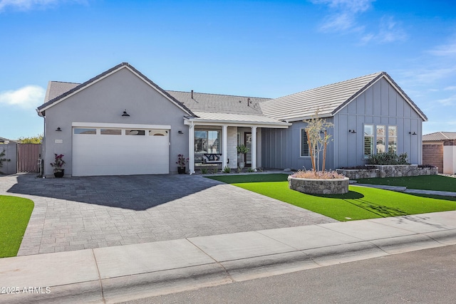 ranch-style house featuring a garage and a front lawn