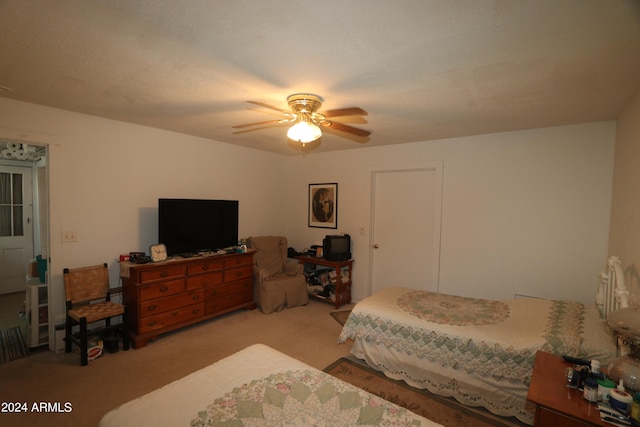 bedroom featuring a textured ceiling, ceiling fan, and light carpet