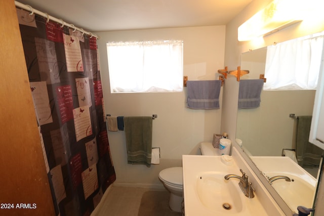 bathroom featuring toilet, a shower with shower curtain, and sink