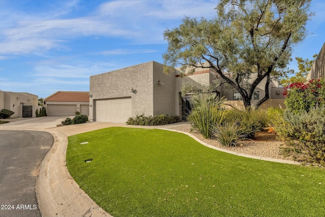 southwest-style home featuring a front lawn and a garage