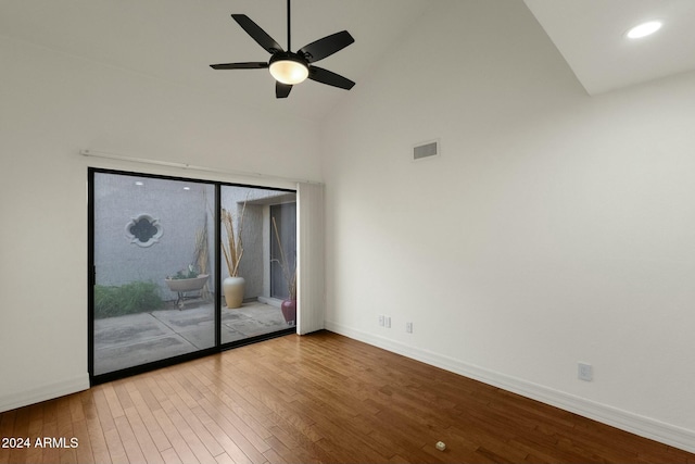 empty room with ceiling fan, high vaulted ceiling, and wood-type flooring