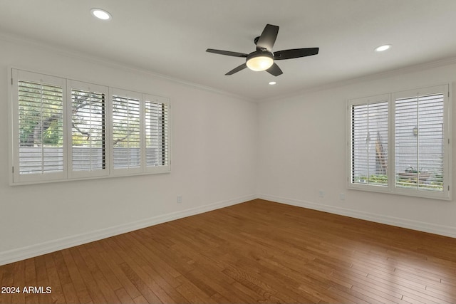 spare room with ornamental molding, a healthy amount of sunlight, and hardwood / wood-style flooring