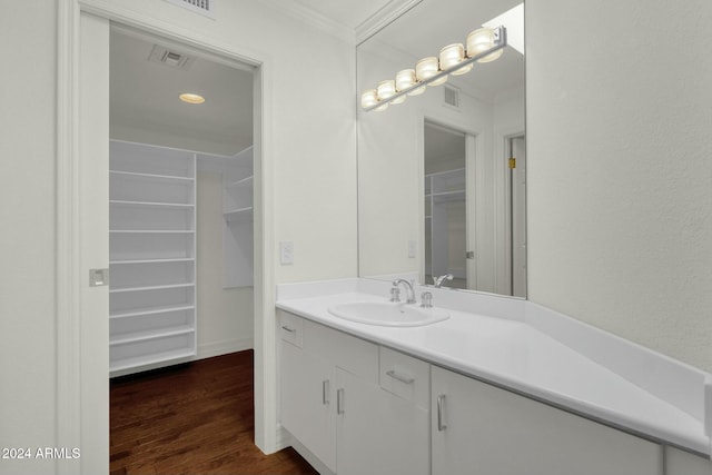 bathroom with hardwood / wood-style floors, vanity, and ornamental molding