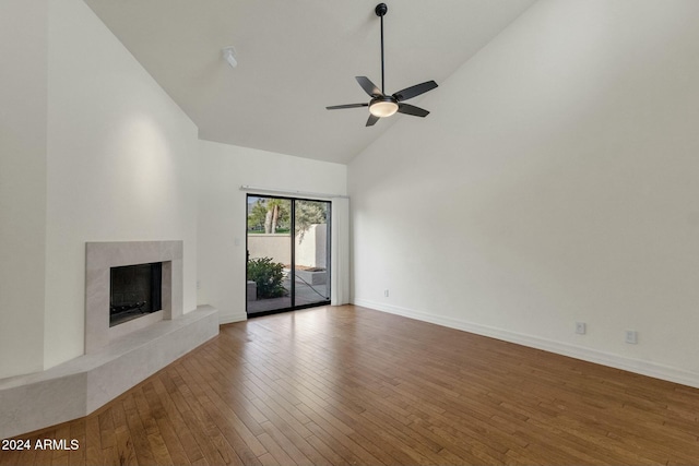 unfurnished living room with hardwood / wood-style flooring, ceiling fan, a premium fireplace, and high vaulted ceiling