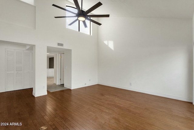 unfurnished living room featuring ceiling fan, dark wood-type flooring, and high vaulted ceiling