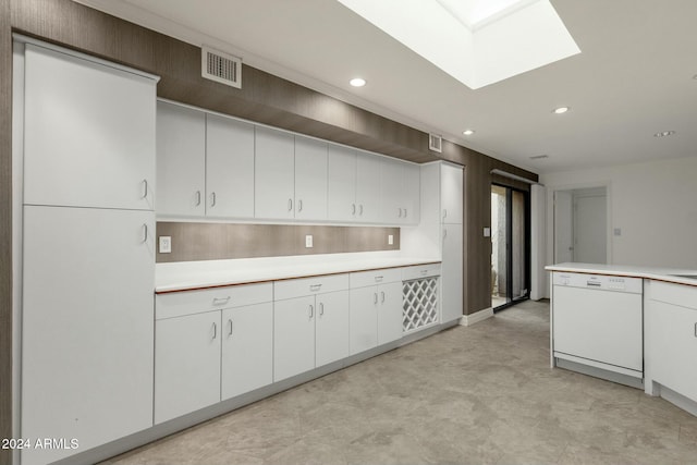 kitchen with white cabinets, white dishwasher, and a skylight