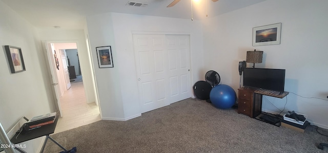 carpeted home office with ceiling fan