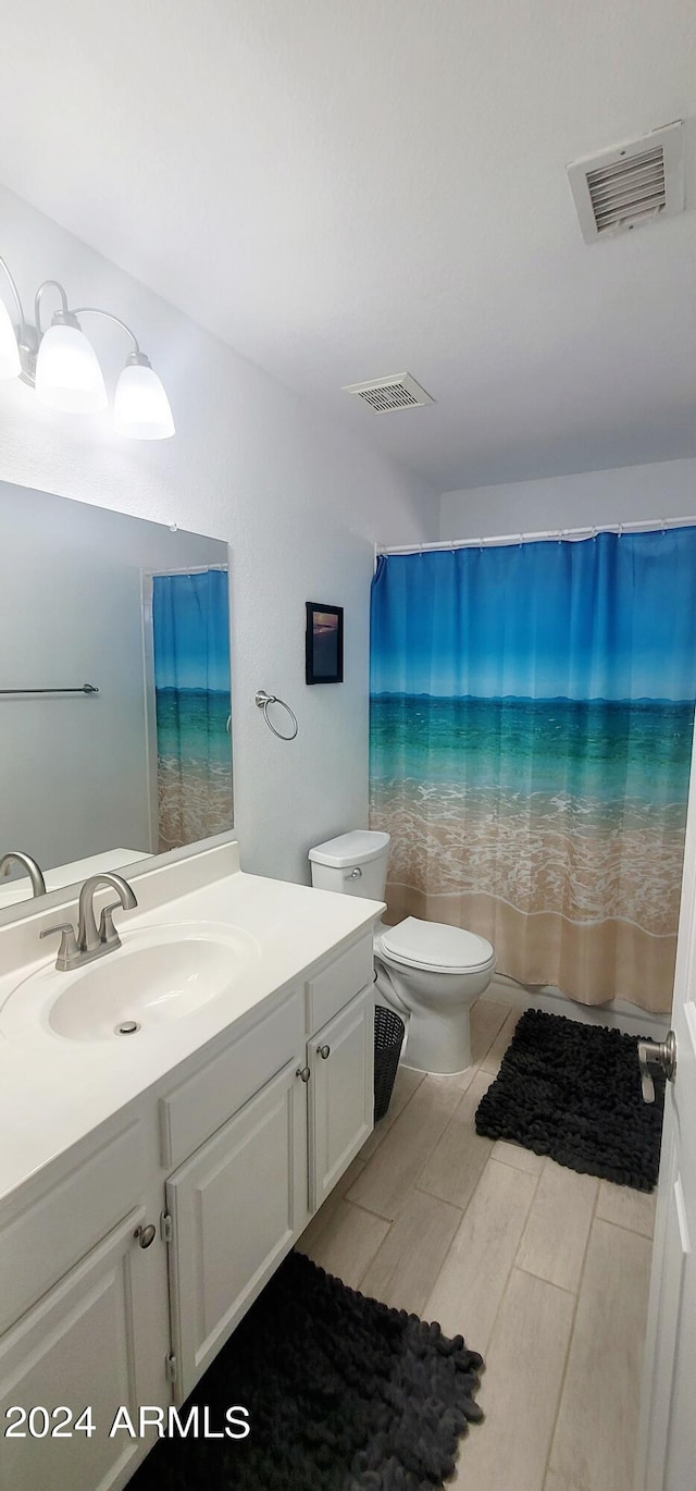 bathroom with vanity, toilet, walk in shower, and hardwood / wood-style floors