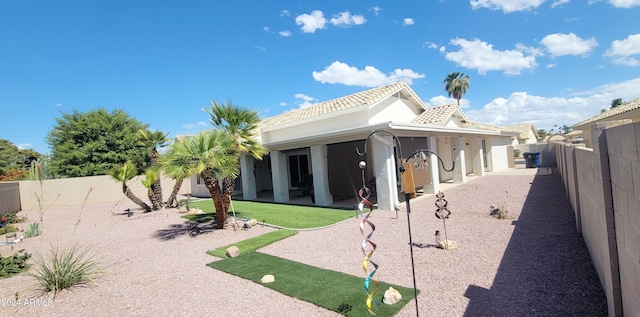 rear view of property featuring a patio area and a lawn