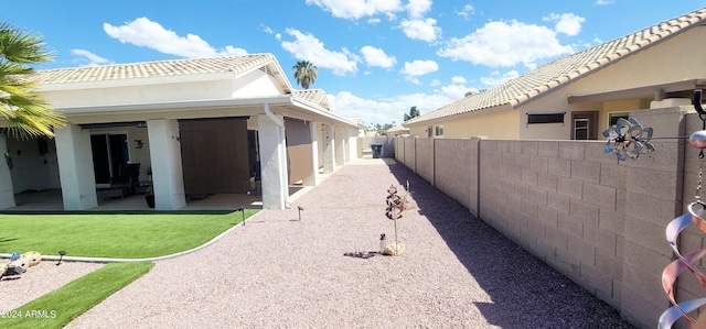 view of property exterior with a patio and a yard