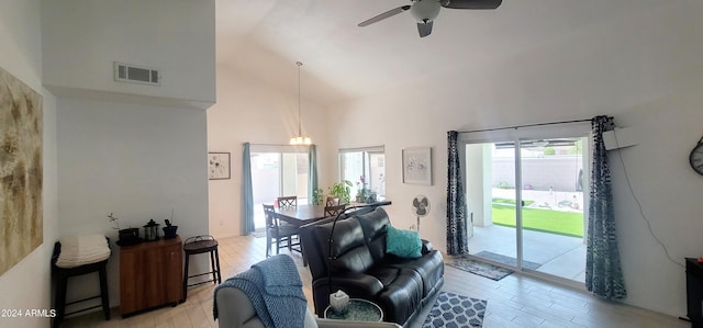 living room featuring high vaulted ceiling, light wood-type flooring, and ceiling fan with notable chandelier