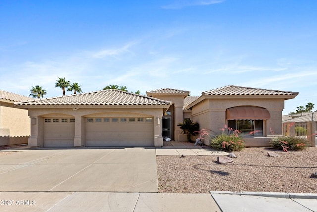 mediterranean / spanish home featuring driveway, a tile roof, fence, an attached garage, and stucco siding