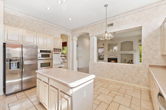 kitchen featuring wallpapered walls, appliances with stainless steel finishes, a healthy amount of sunlight, and visible vents