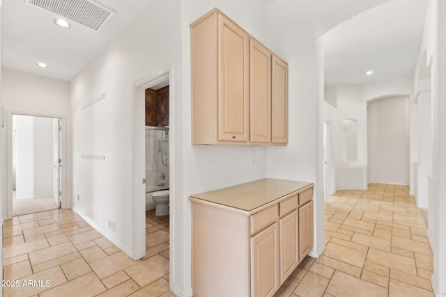 hall with visible vents, arched walkways, baseboards, and recessed lighting