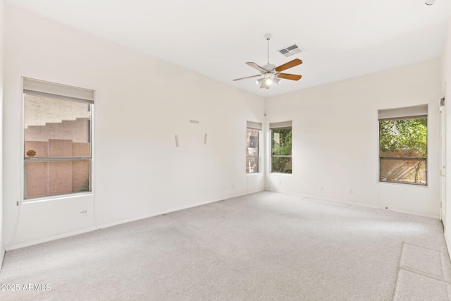 unfurnished room featuring carpet floors, plenty of natural light, a ceiling fan, and visible vents