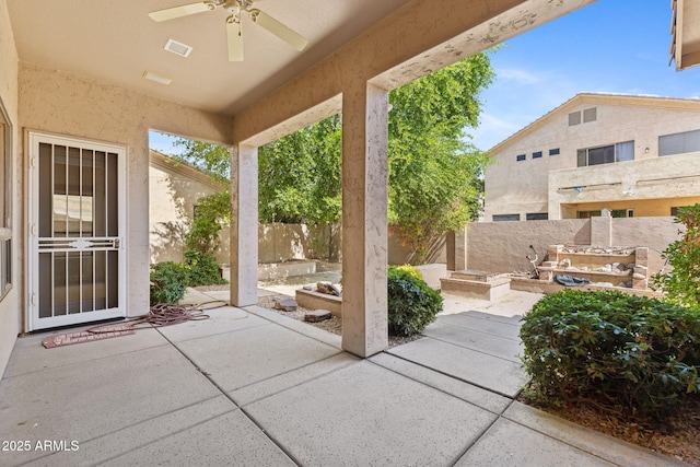 view of patio with a fenced backyard, a ceiling fan, and visible vents