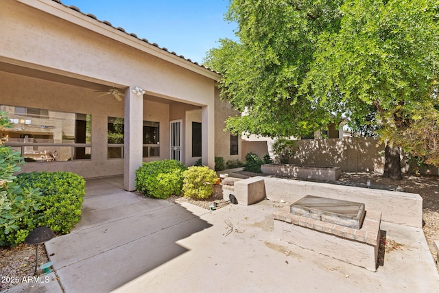 view of patio featuring an outdoor fire pit and fence