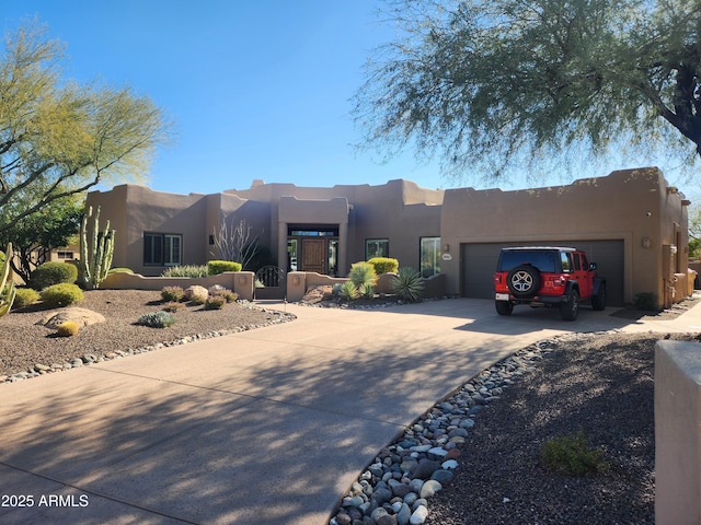 pueblo-style house featuring a garage