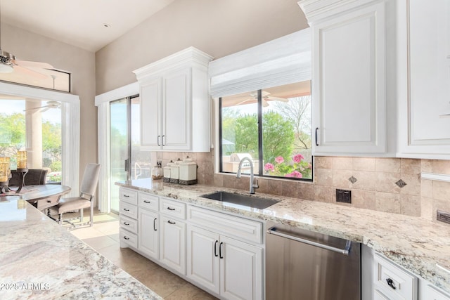 kitchen with light tile patterned flooring, sink, white cabinetry, tasteful backsplash, and stainless steel dishwasher