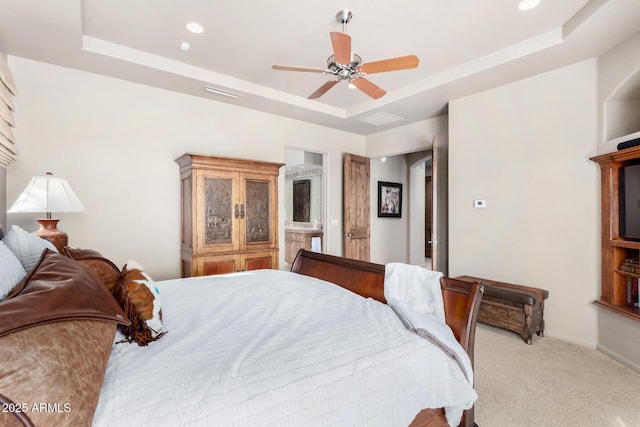 carpeted bedroom featuring a raised ceiling and ceiling fan