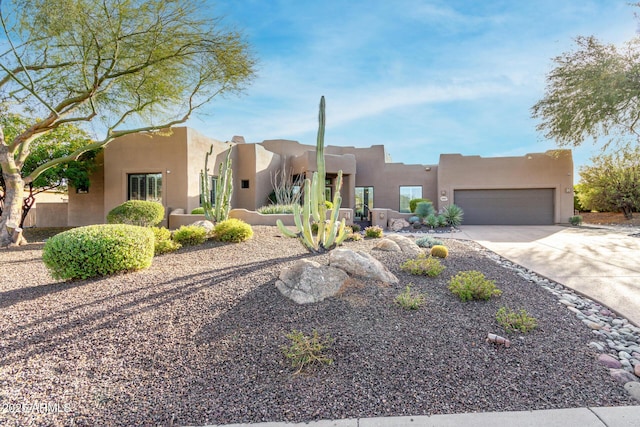 pueblo-style home featuring a garage