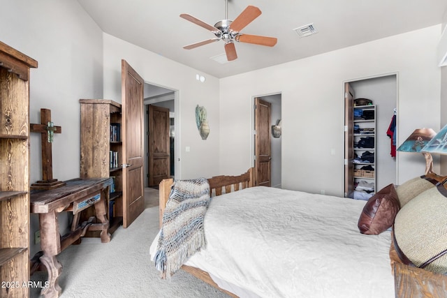 carpeted bedroom with a spacious closet, a closet, and ceiling fan