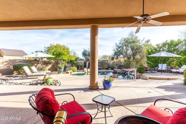 view of patio / terrace with a fenced in pool and ceiling fan