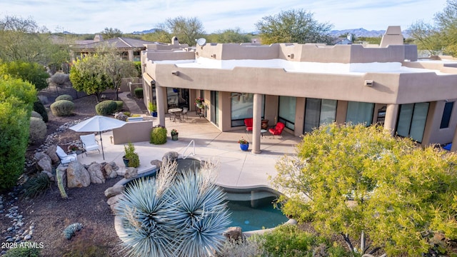 rear view of property with a mountain view and a patio