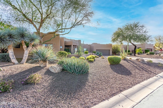 pueblo-style home featuring a garage