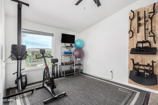 workout area with lofted ceiling, wainscoting, and a ceiling fan