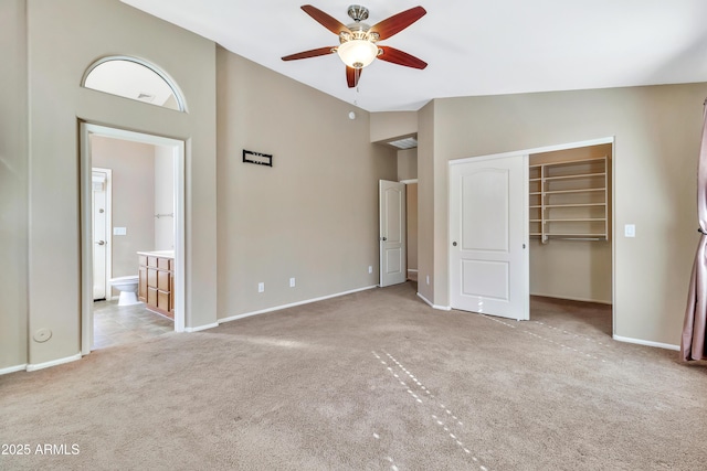 unfurnished bedroom with ceiling fan, light carpet, high vaulted ceiling, and a closet