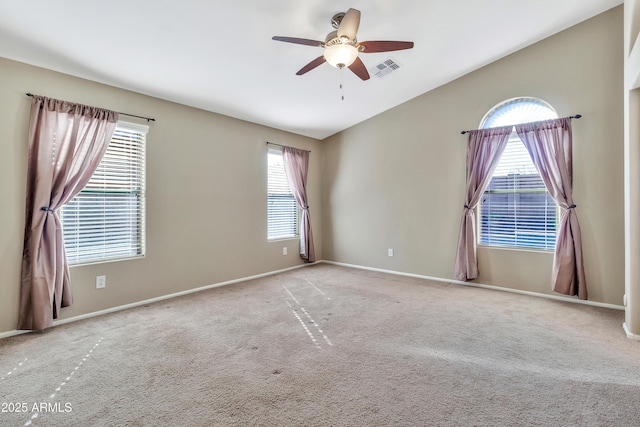 carpeted spare room with plenty of natural light, ceiling fan, and lofted ceiling