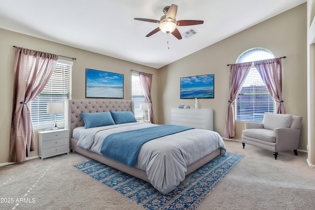 bedroom featuring multiple windows, ceiling fan, light carpet, and vaulted ceiling