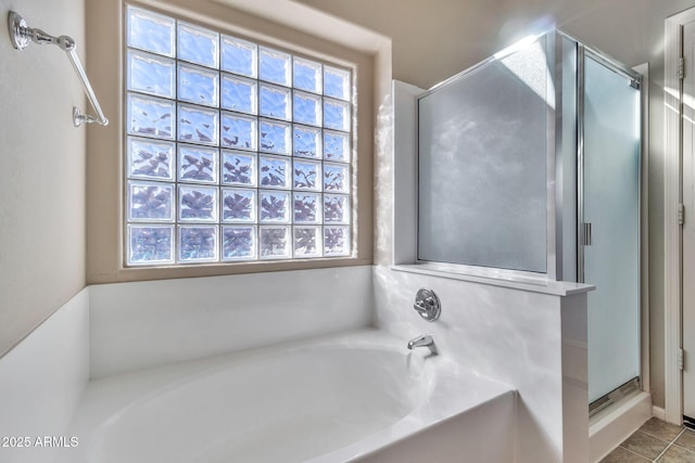 bathroom featuring tile patterned flooring and shower with separate bathtub