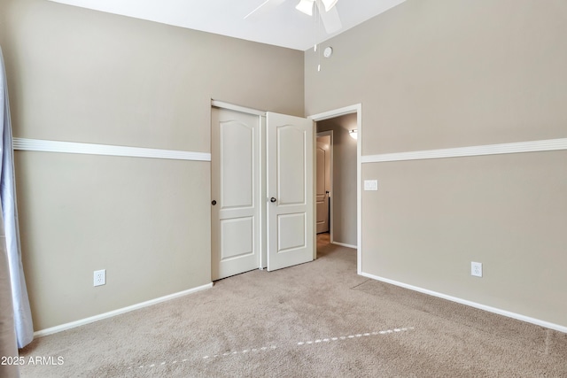 unfurnished bedroom with ceiling fan, a closet, and light colored carpet