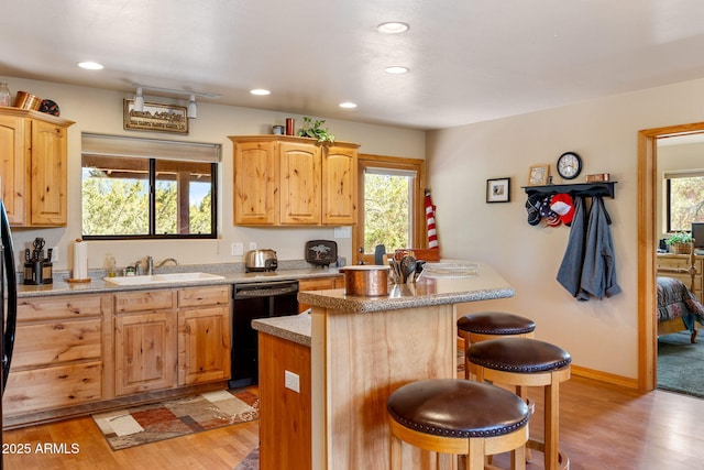 2761 Jaguar Cir, Overgaard, AZ 85933 - kitchen with dishwasher, a sink, a kitchen bar, light wood-type flooring, and a center island