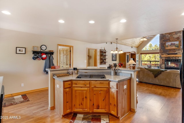 2761 Jaguar Cir, Overgaard, AZ 85933 - kitchen featuring black electric stovetop, ceiling fan, light wood finished floors, open floor plan, and a fireplace