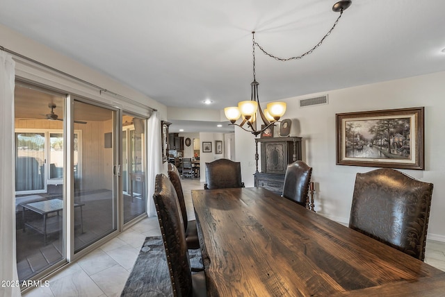 tiled dining area featuring ceiling fan with notable chandelier