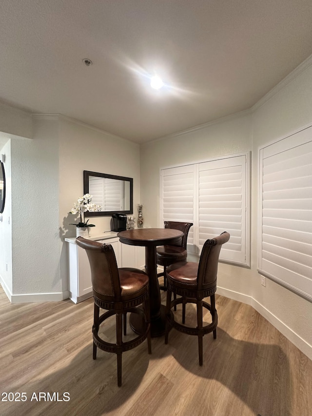 5345 E Van Buren St Unit 216, Phoenix, AZ 85008 - dining area with light wood-style flooring and ornamental molding