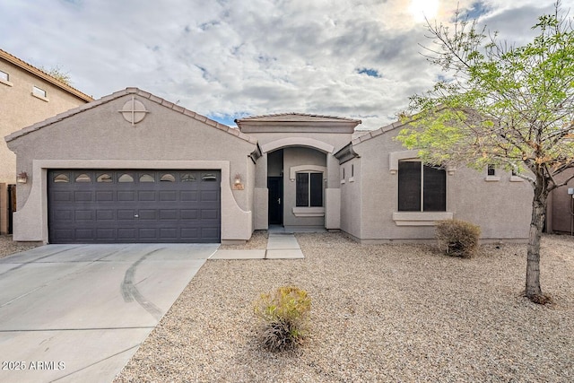 mediterranean / spanish home with stucco siding, a garage, driveway, and a tile roof