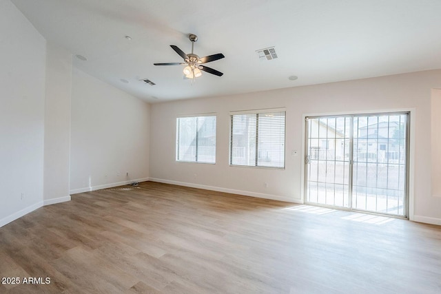 spare room featuring a ceiling fan, wood finished floors, visible vents, and baseboards