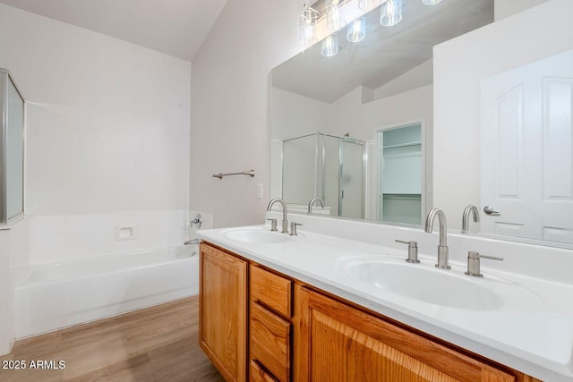 15853 N 74th Ave, Peoria, AZ 85382 - bathroom featuring a garden tub, wood finished floors, a stall shower, and a sink
