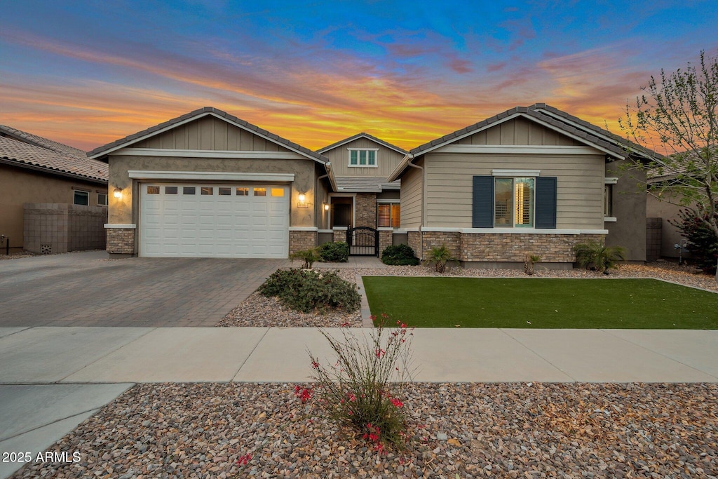 view of front facade with a garage, decorative driveway, fence, and board and batten siding