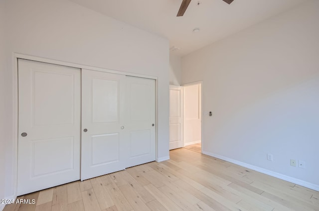 unfurnished bedroom featuring a closet, light hardwood / wood-style flooring, and ceiling fan