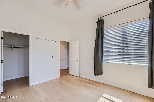 unfurnished bedroom with light hardwood / wood-style floors, a closet, and ceiling fan