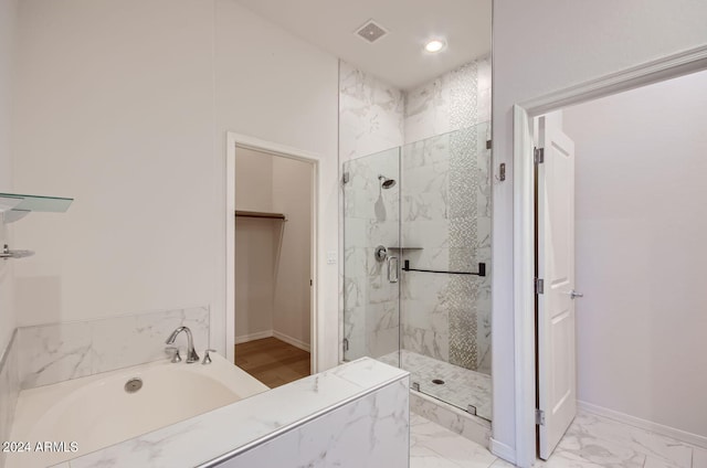 bathroom featuring separate shower and tub