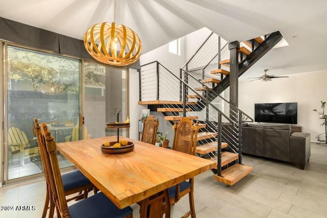 tiled dining room featuring ceiling fan with notable chandelier