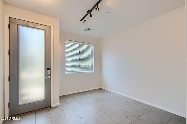 spare room featuring light tile patterned floors and track lighting