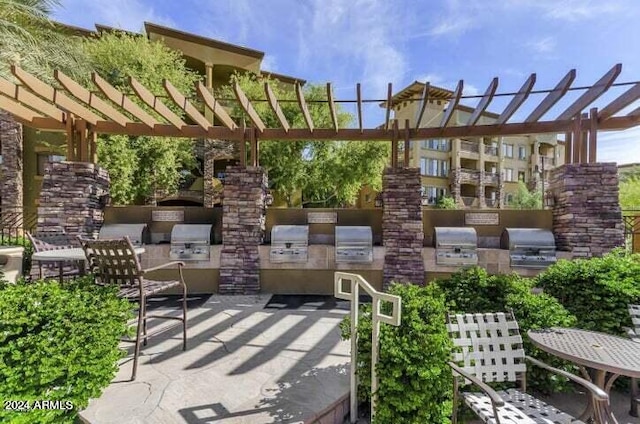 view of patio featuring a pergola, an outdoor kitchen, and grilling area